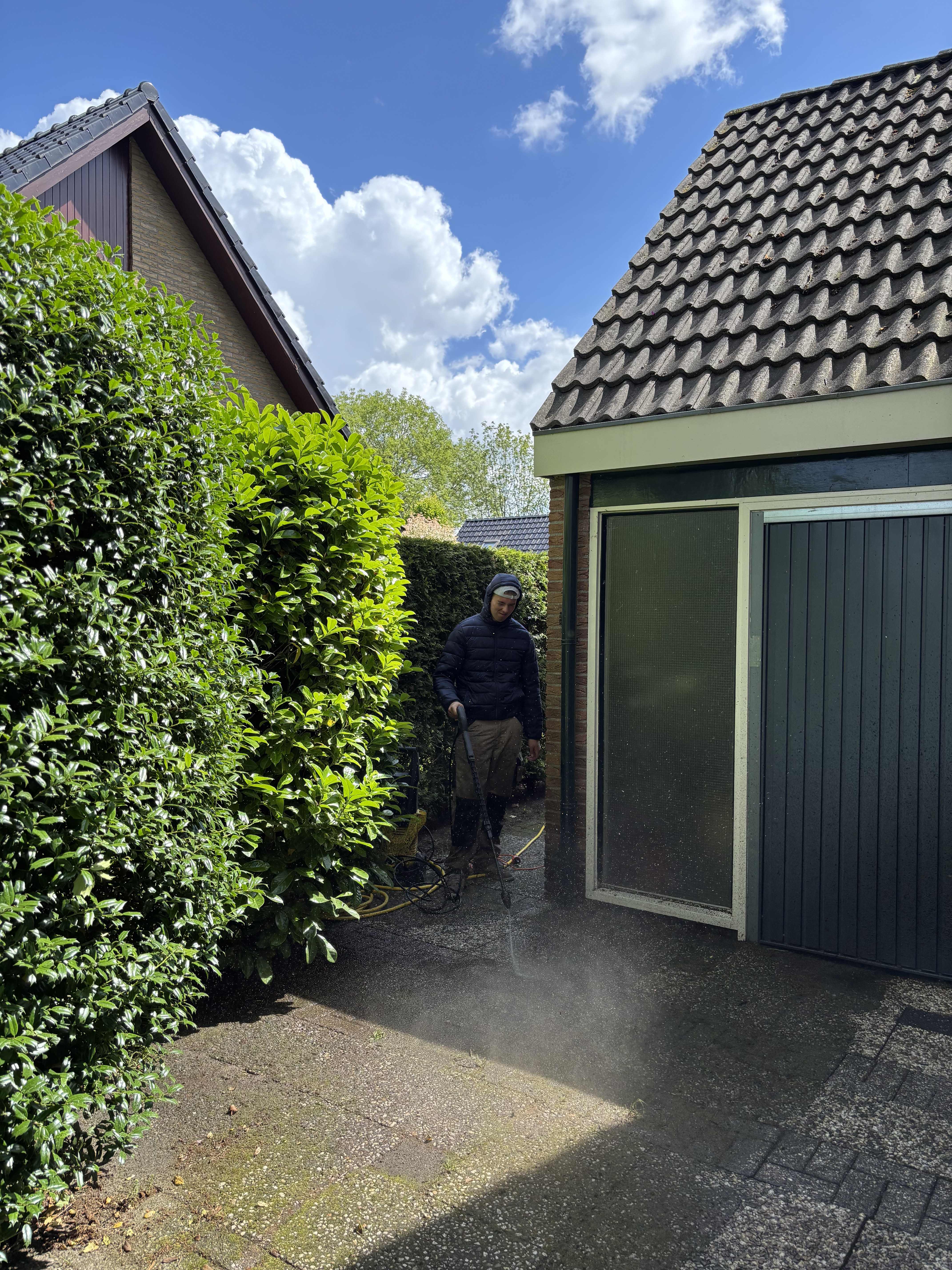 Oprit schoongespoten met hogedrukspuit en onkruid verwijderd in De Wijk door QJ Service en Onderhoud